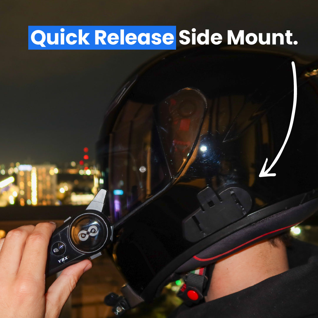 Person adjusting a quick release side mount on a helmet with a cityscape in the background.